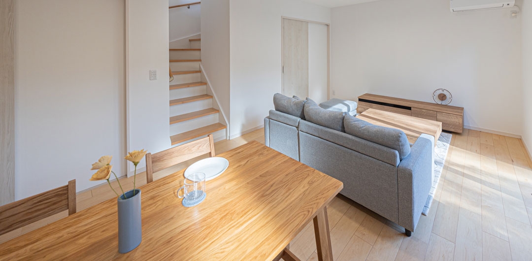 ダイニングテーブル越しにリビングと階段が見えるLDK。生活動線がつながる間取り。